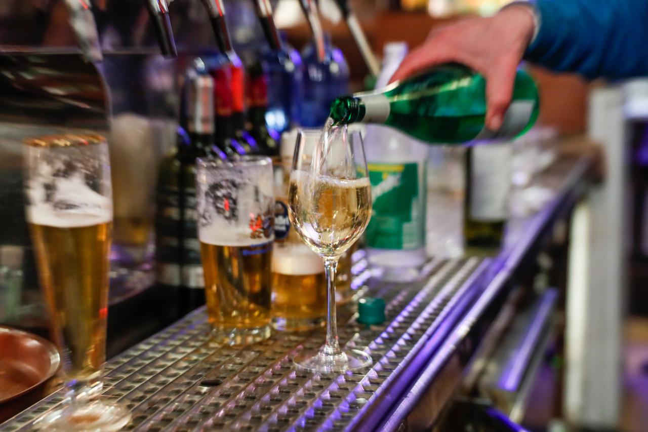 In einer Bar wird ein Glas Wein eingeschenkt. In einer Bar wird ein Glas Wein eingeschenkt.