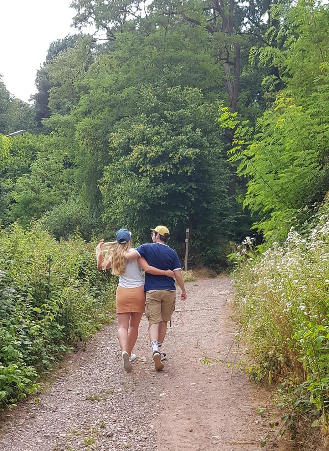 Die nachgestellte Szene des Kinderfotos von Vanessa und Philipp nach 17 Jahren, sie laufen Arm in Arm einen Waldweg entlang. Die nachgestellte Szene des Kinderfotos von Vanessa und Philipp nach 17 Jahren, sie laufen Arm in Arm einen Waldweg entlang.