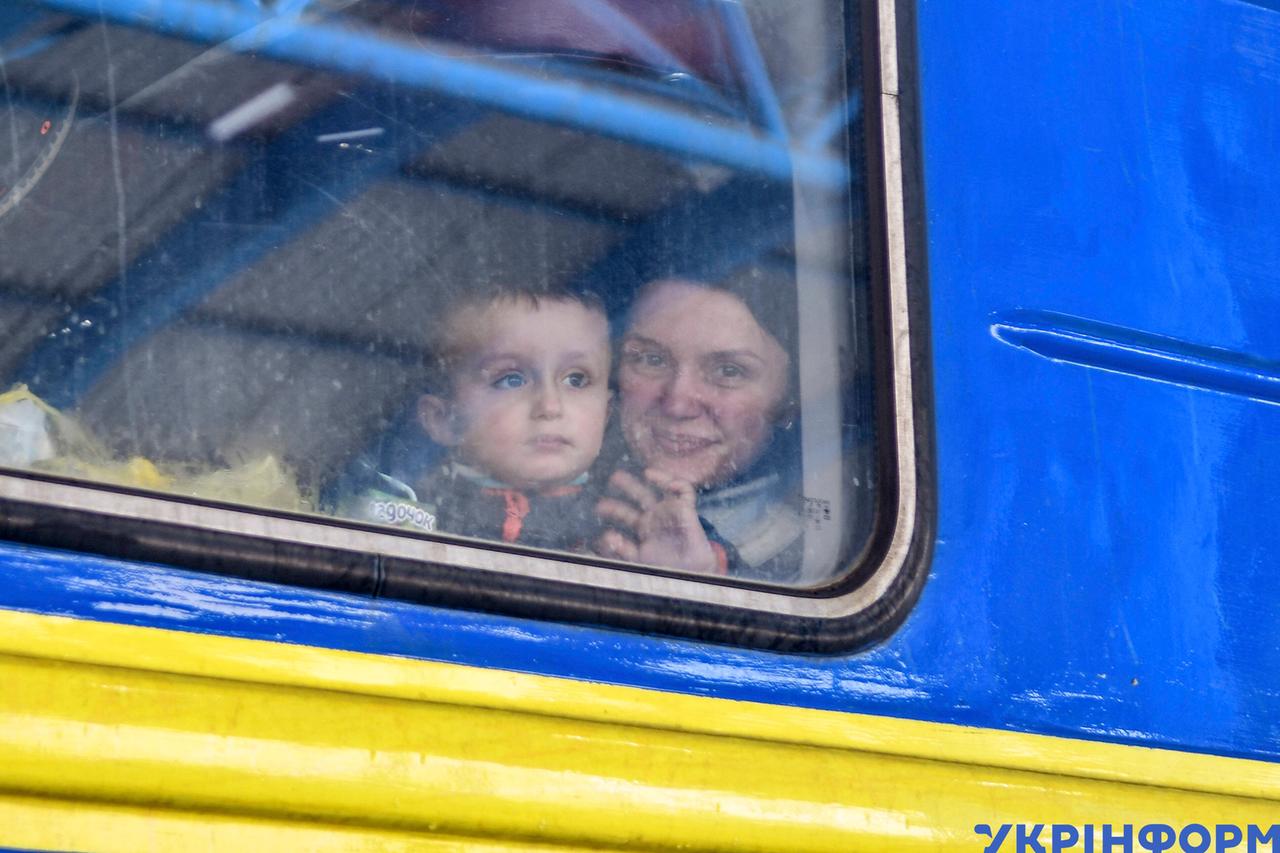 Eine Frau sitzt mit Kind in einem Evakuierungszug aus der Stadt Saporischschja. Eine Frau sitzt mit Kind in einem Evakuierungszug aus der Stadt Saporischschja.