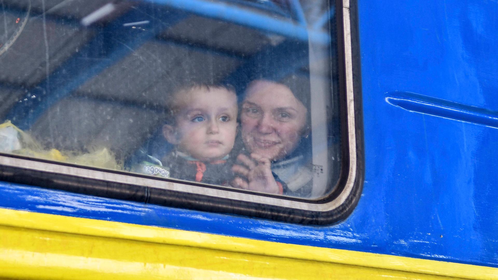 Eine Frau sitzt mit Kind in einem Evakuierungszug aus der Stadt Saporischschja. Eine Frau sitzt mit Kind in einem Evakuierungszug aus der Stadt Saporischschja.