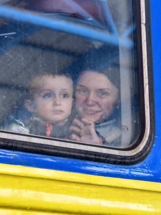 Eine Frau sitzt mit Kind in einem Evakuierungszug aus der Stadt Saporischschja.