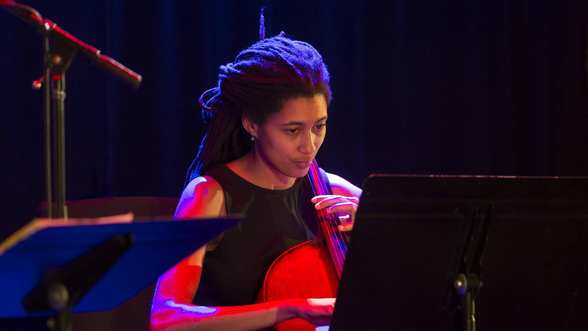 Auf dem Bild ist eine Schwarze Frau am Cello zu sehen, die Cellistin Tomeka Reid. Auf dem Bild ist eine Schwarze Frau am Cello zu sehen, die Cellistin Tomeka Reid.