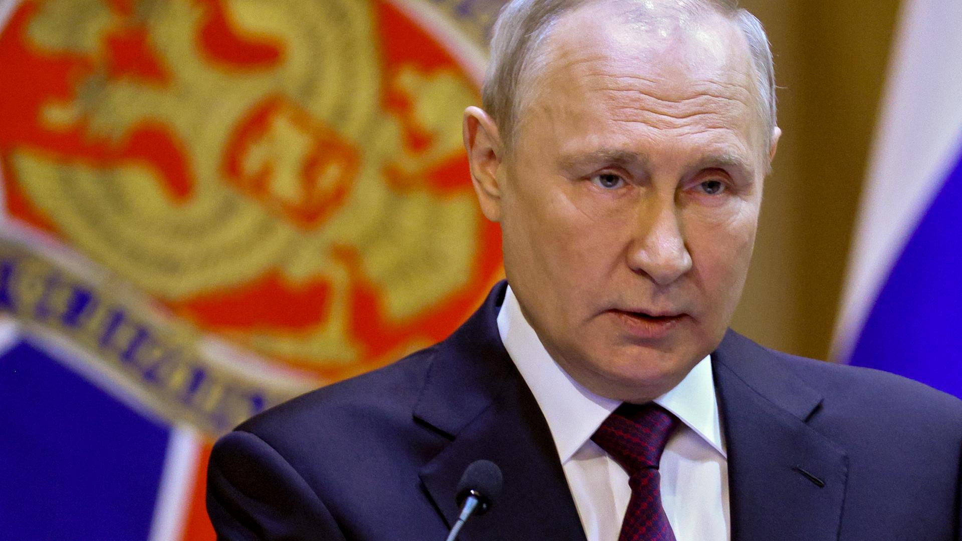 Der russische Präsident Putin hält eine Rede vor einer russischen Flagge.
