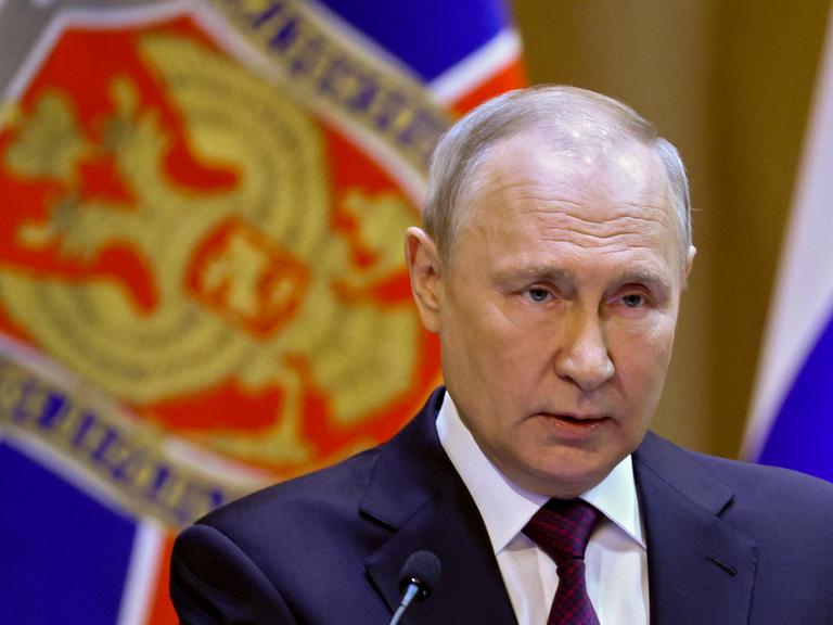 Der russische Präsident Putin hält eine Rede vor einer russischen Flagge.
