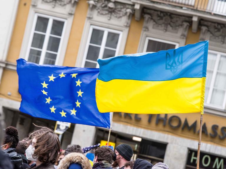 Auf einer Demonstration sind die europäische und die ukrainische Flagge zu sehen.