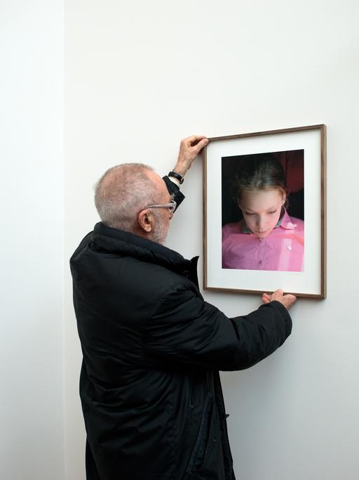 Der Maler Gerhard Richter hängt ein Bild seiner Tochter Ella auf.