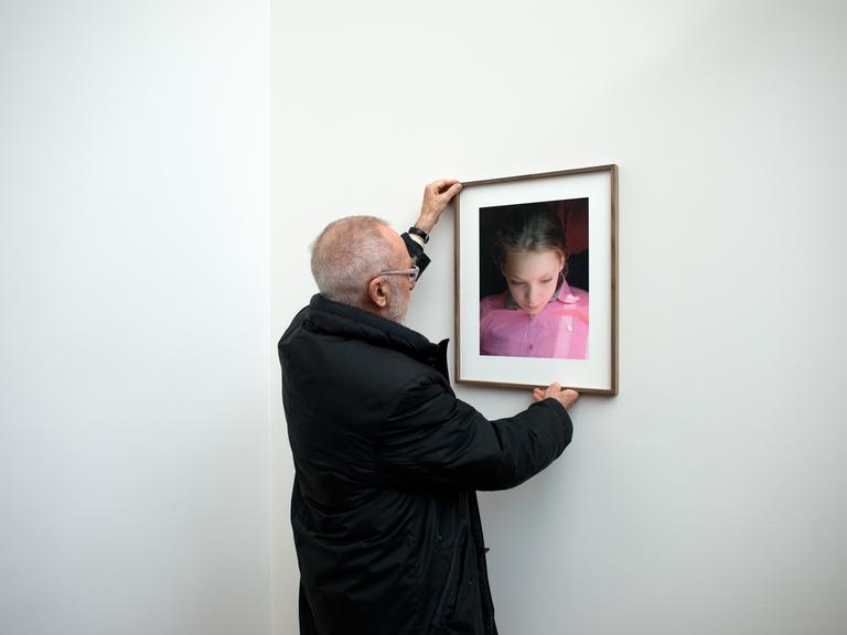 Der Maler Gerhard Richter hängt ein Bild seiner Tochter Ella auf.