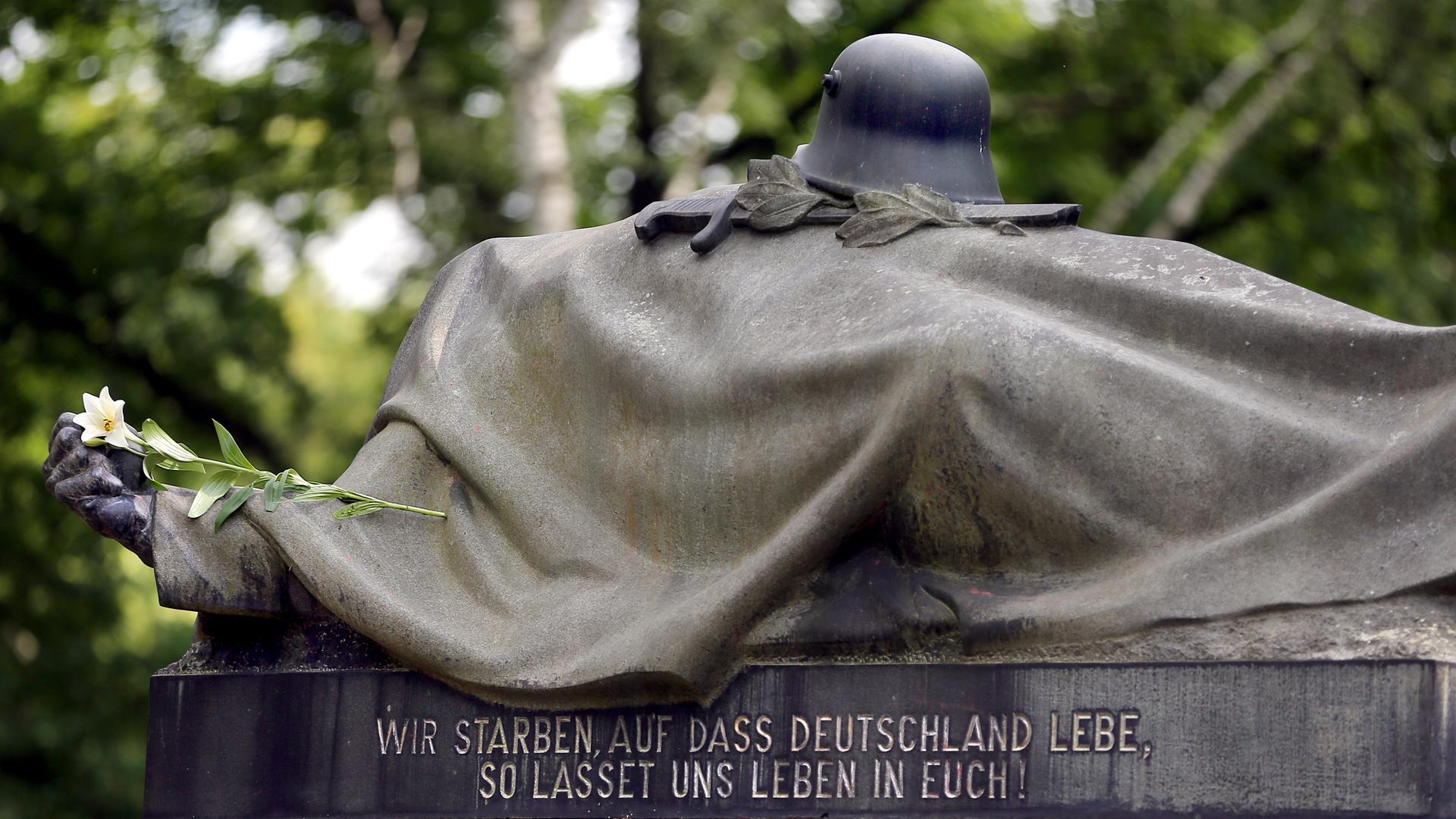 Eine weiße Lilie liegt auf einem Kriegerdenkmal des Garnisonsfriedhofes in Berlin und erinnert an die gefallenen Soldaten des Ersten Weltkriegs. Eine weiße Lilie liegt auf einem Kriegerdenkmal des Garnisonsfriedhofes in Berlin und erinnert an die gefallenen Soldaten des Ersten Weltkriegs.