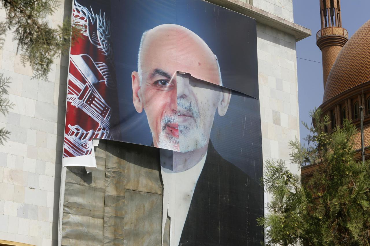 Ein zerrisssenes Plakat mit dem Porträt des ehemaligen afghanischen Präsidenten Ashraf Ghani hängt an einer Hauswand.