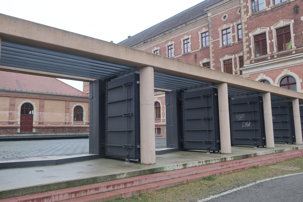 Vor einem Gebäude sind meterhohe Stahltore montiert. Vor einem Gebäude sind meterhohe Stahltore montiert.