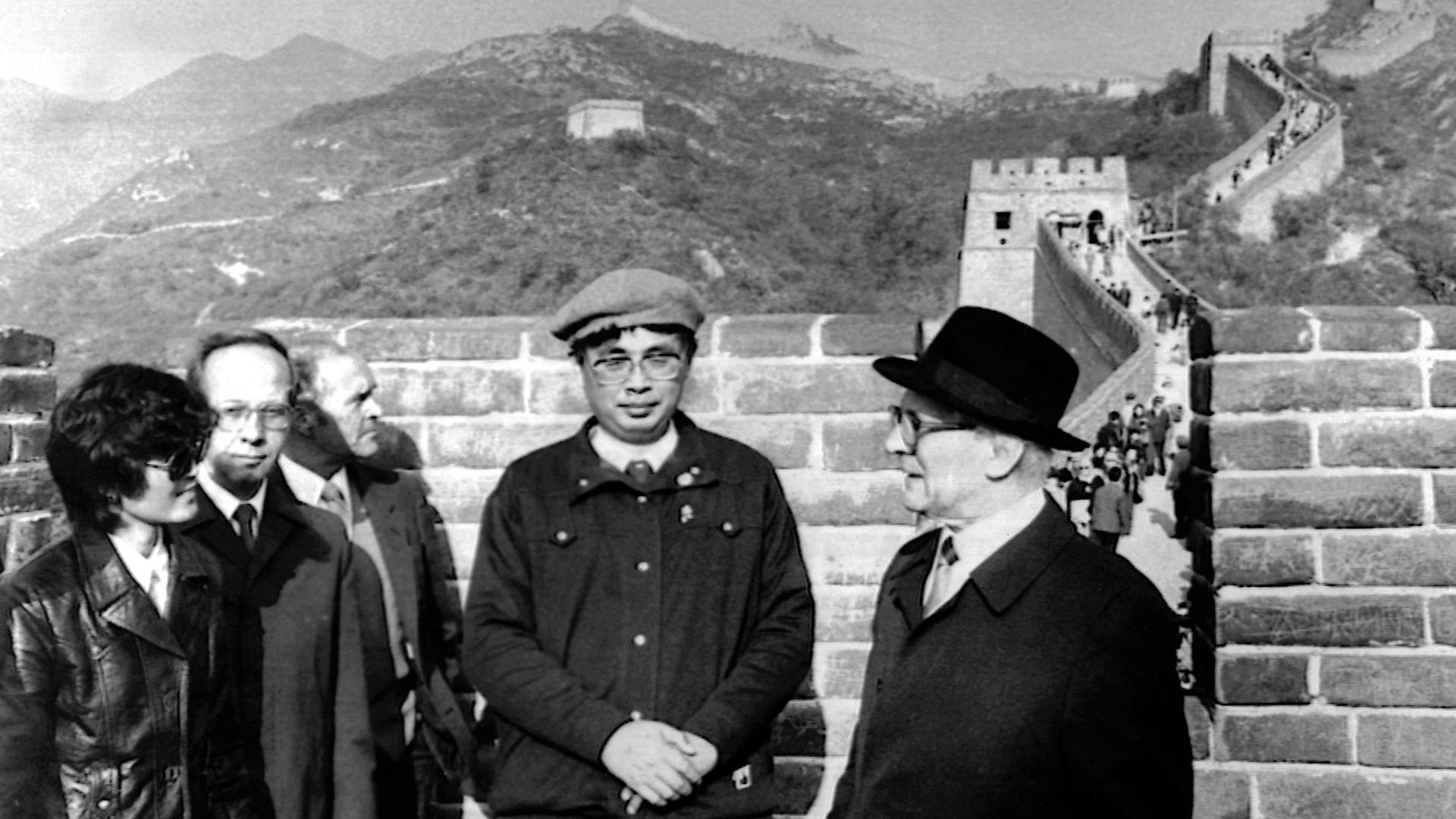 Chinesische Männer udn ein Europäer mit Hut stehen auf der Großen Mauer in China. Chinesische Männer udn ein Europäer mit Hut stehen auf der Großen Mauer in China.