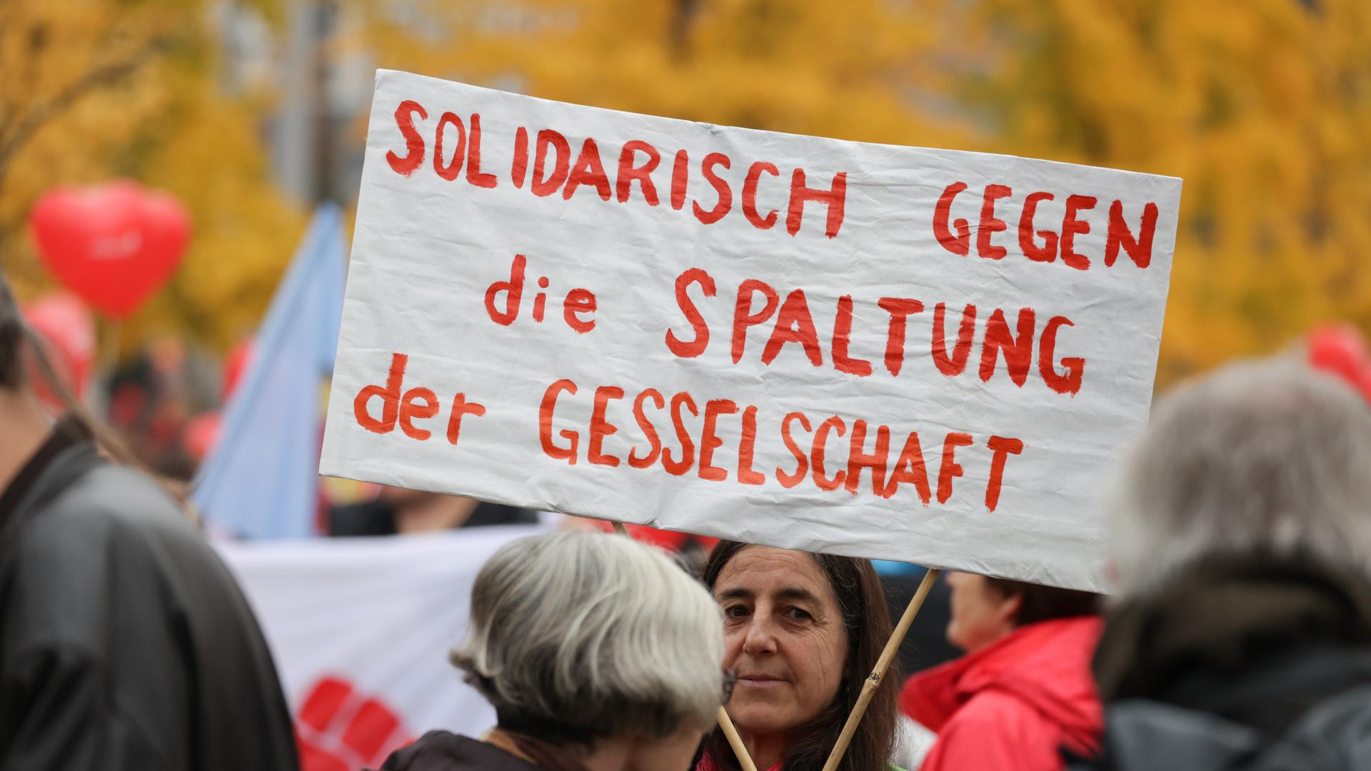 Ein Transparent mit der Aufschrift "Solidarisch gegen die Spaltung der Gesellschaft" ist bei einer Demonstration zu sehen. Ein Transparent mit der Aufschrift "Solidarisch gegen die Spaltung der Gesellschaft" ist bei einer Demonstration zu sehen.