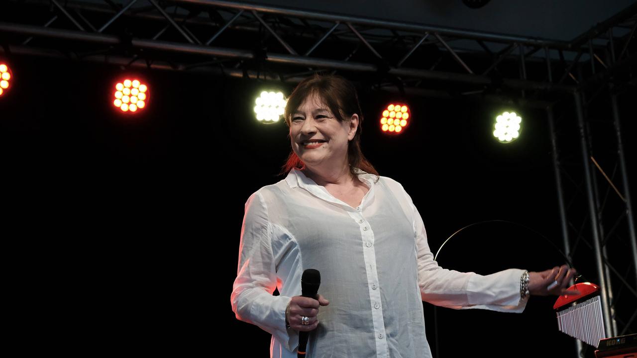 Ulla Meinecke steht auf einer Konzertbühne und hat ein Mikrofon in der Hand.