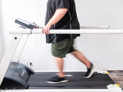 Ein Mann trainiert an einem Laufband um seine Ausdauer nach einer Coronainfektion zu stärken.