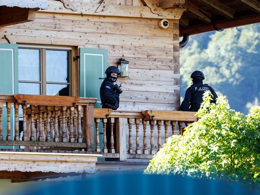 Maskierte Polizisten stehen bei einer Razzia auf einem Balkon von einem Haus des russischen Oligarchen Usmanow. 
