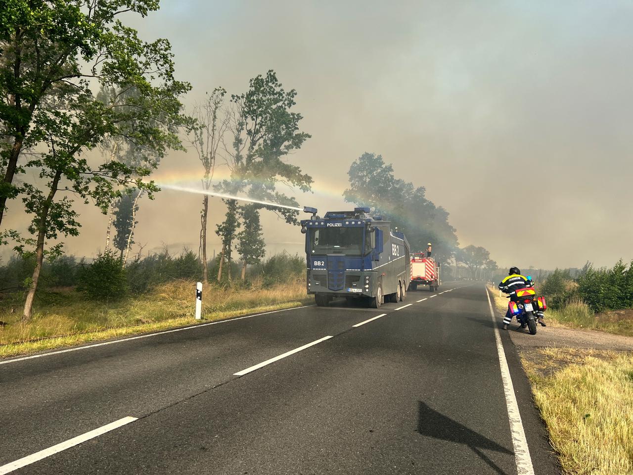 Ein Wasserwerfer der Polizei ist in einem Waldstück bei Treuenbrietzen bei einem Waldbrand im Einsatz. Ein Wasserwerfer der Polizei ist in einem Waldstück bei Treuenbrietzen bei einem Waldbrand im Einsatz.
