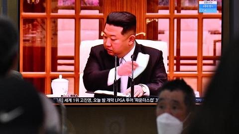 Seoul, Nordkorea: Menschen sitzen vor einem Bildschirm, auf dem eine Rede von Machthaber Kim Jong Un übertragen wird. Angesichts eines offiziell ersten Corona-Ausbruchs verkündet er landesweite Lockdowns.