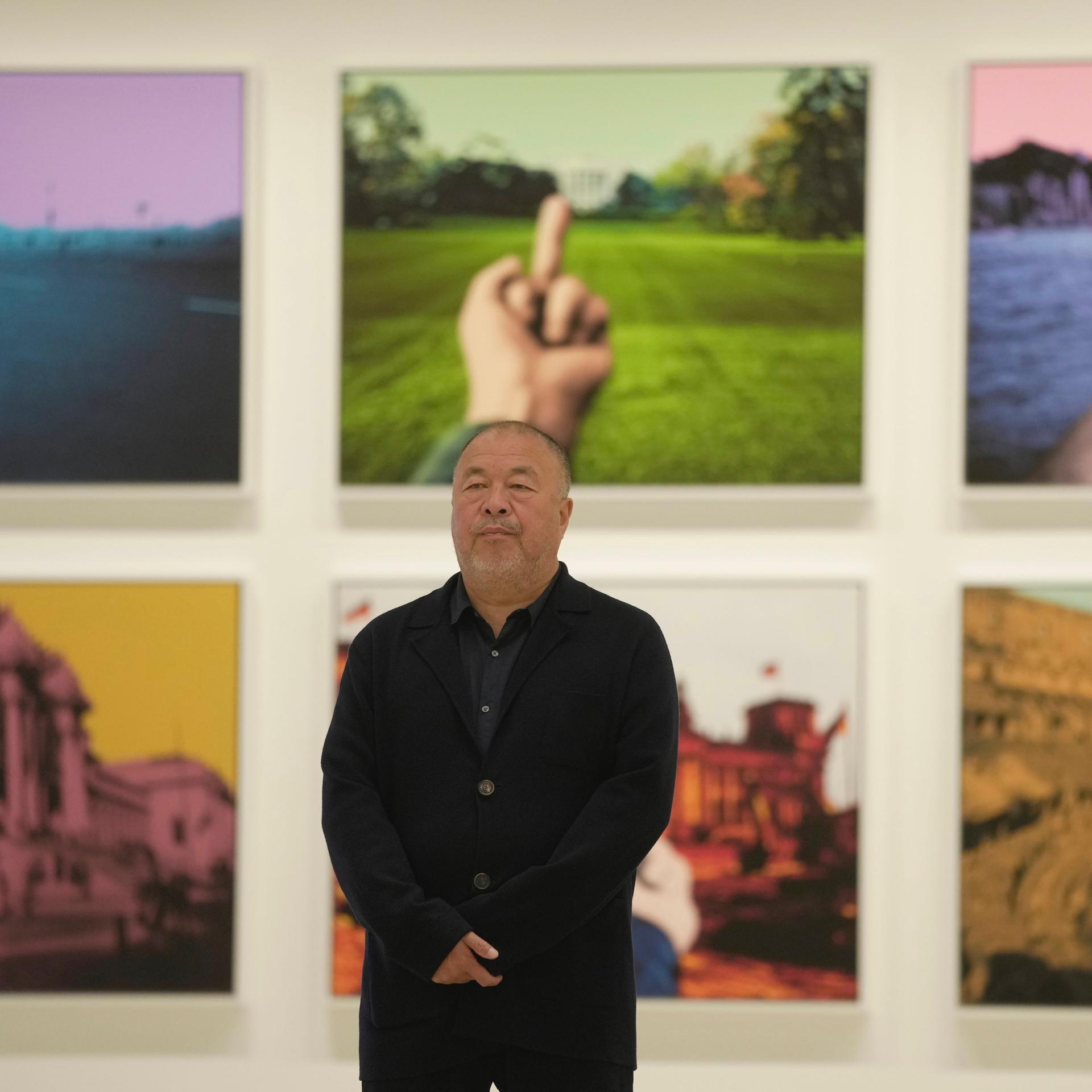 Der chinesische Künstler Ai Weiwei vor sechs seiner fotografischen Kunstwerke, die an einer Wand hängen.
