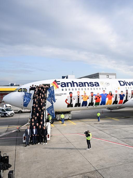 Das Lufthansa-Flugzeug der deutschen Fussball-Nationalmannschaft auf dem Rollfeld am Flughafen Frankfurt. Die Mannschaft steht auf der Zugansgtreppe des Flugzeugs.