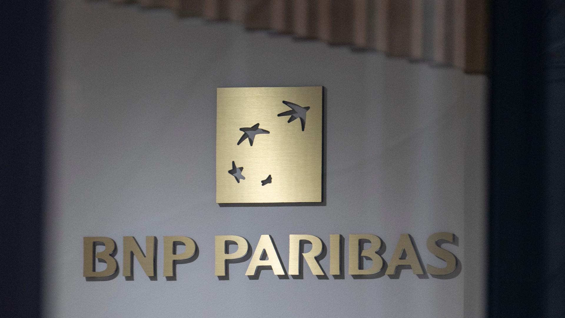 Ein Schild der BNP Paribas mit goldenen Lettern an einem Gebäude in Frankfurt.