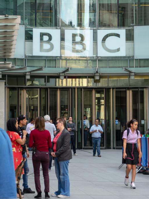 Menschen stehen und gehen vor dem Eingang des Broadcasting House in London, dem Hauptsitz der British Broadcasting Corporation (BBC). Foto vom 09. Mai 2018.