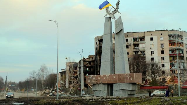 Eine ukranische Flagge weht an einem Denkmal vor bei Angriffen der russischen Armee zerstörten Häusern in der Siedlung Borodjanka bei Kiew 