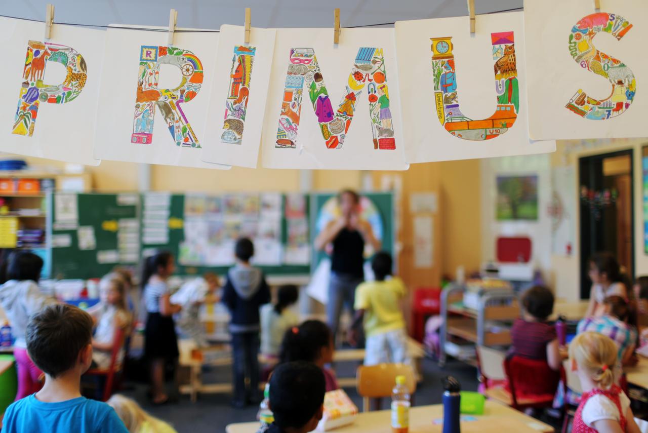 Ein Banner mit der Aufschrift "Primus-Schule" und eine Schulklasse. Ein Banner mit der Aufschrift "Primus-Schule" und eine Schulklasse.