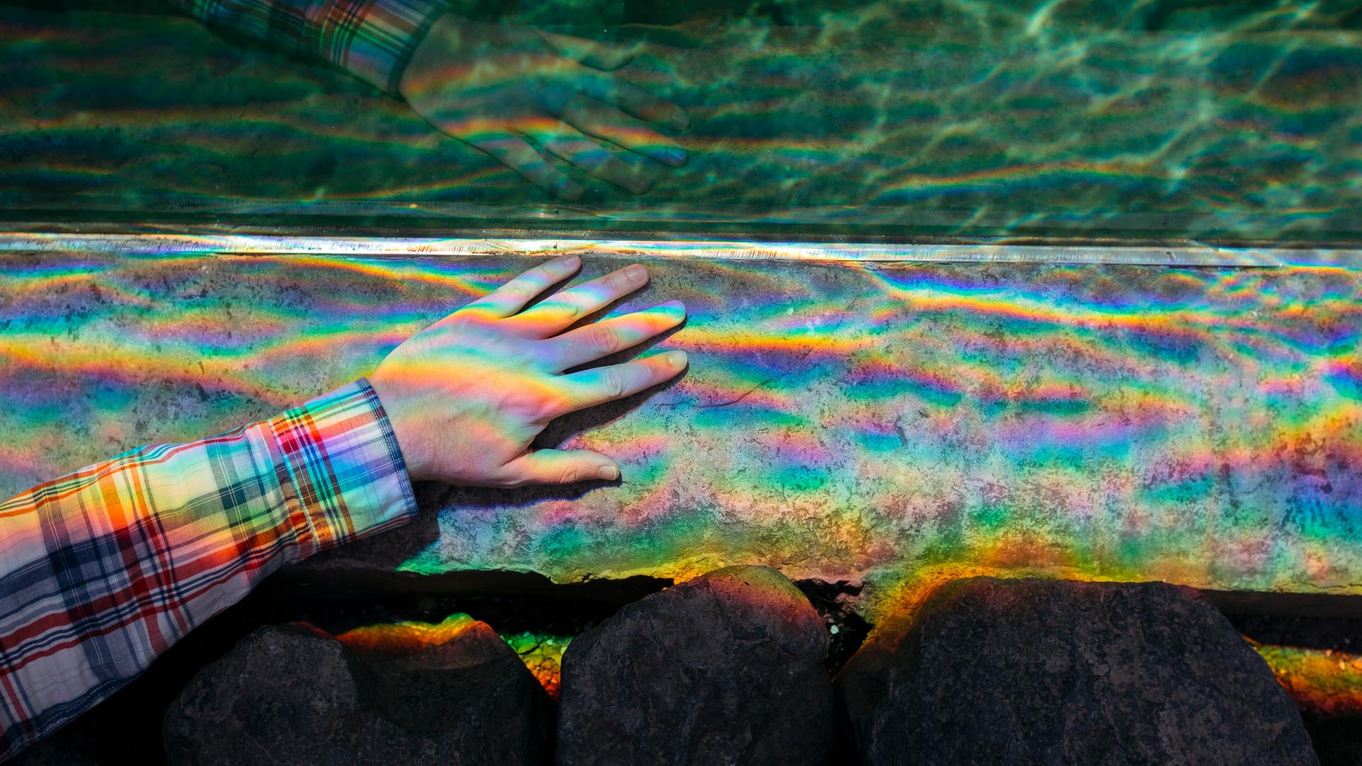 Auf einer Hand bricht sich Licht in allen Regenbogenfarben. Auf einer Hand bricht sich Licht in allen Regenbogenfarben.
