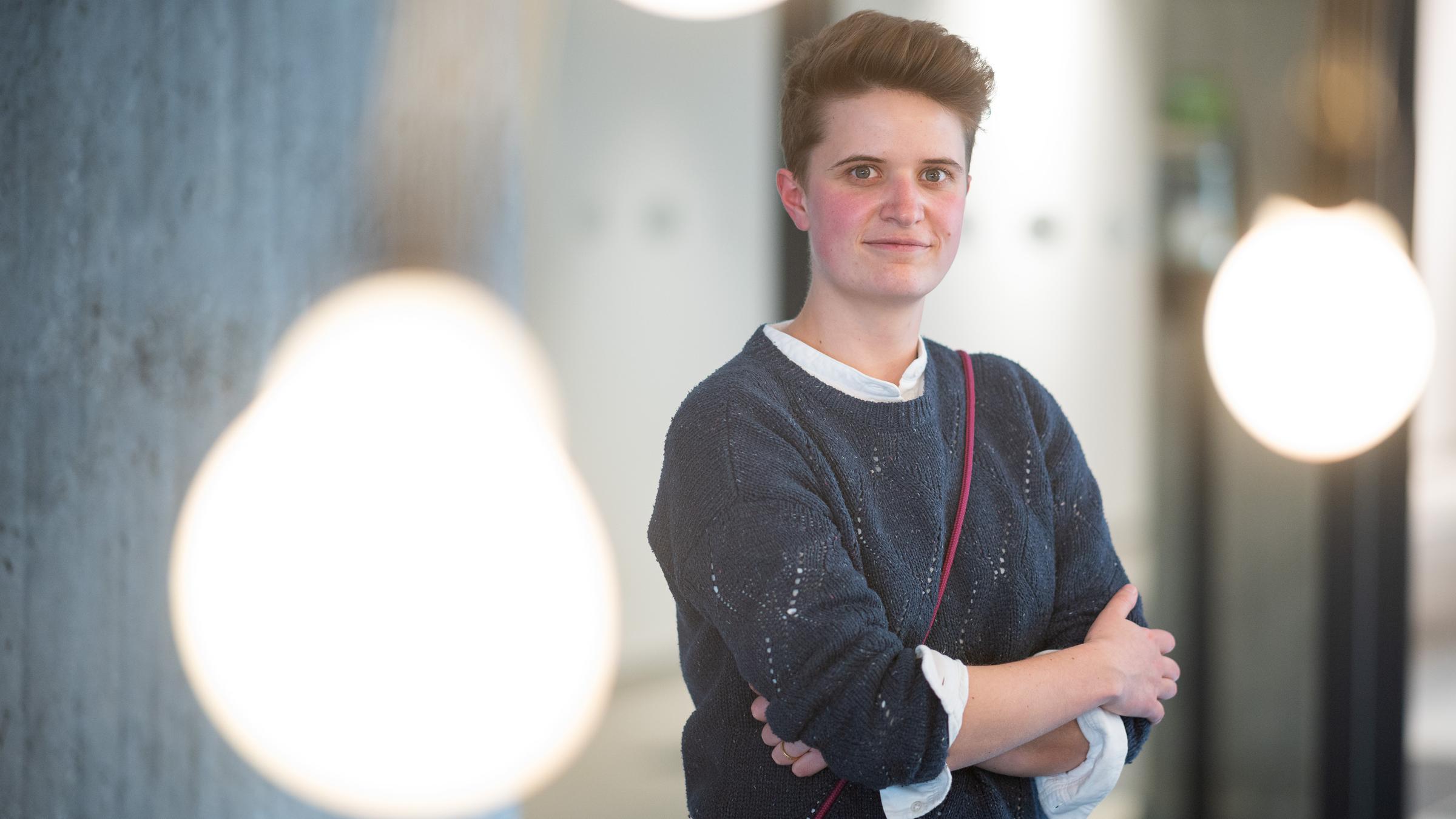 Anna-Nicole Heinrich, Präses der 13. Synode der Evangelischen Kirche in Deutschland \(EKD\), steht hinter leuchtenden Glühbirnen.