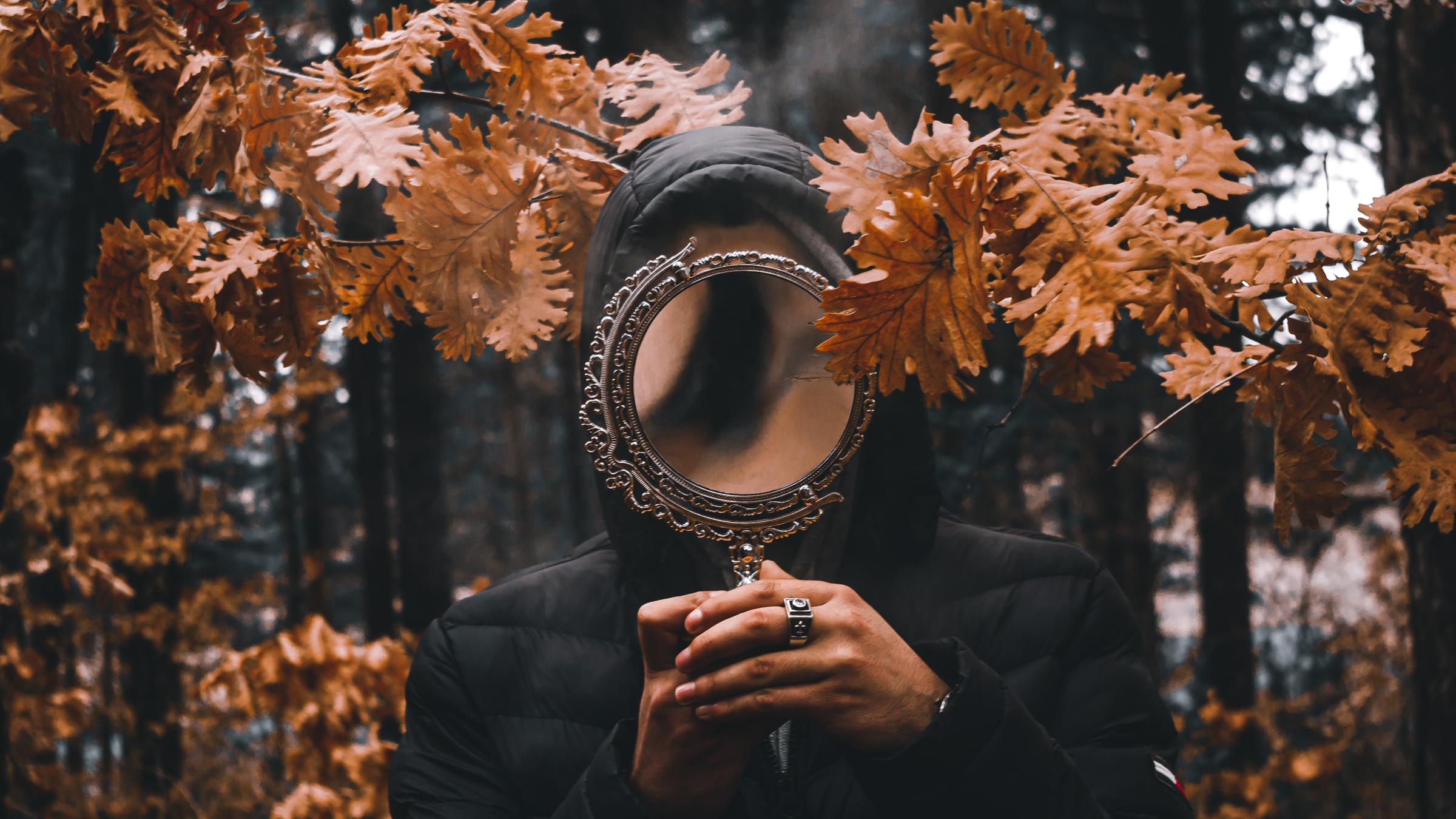 Person hät einen Spiegel.