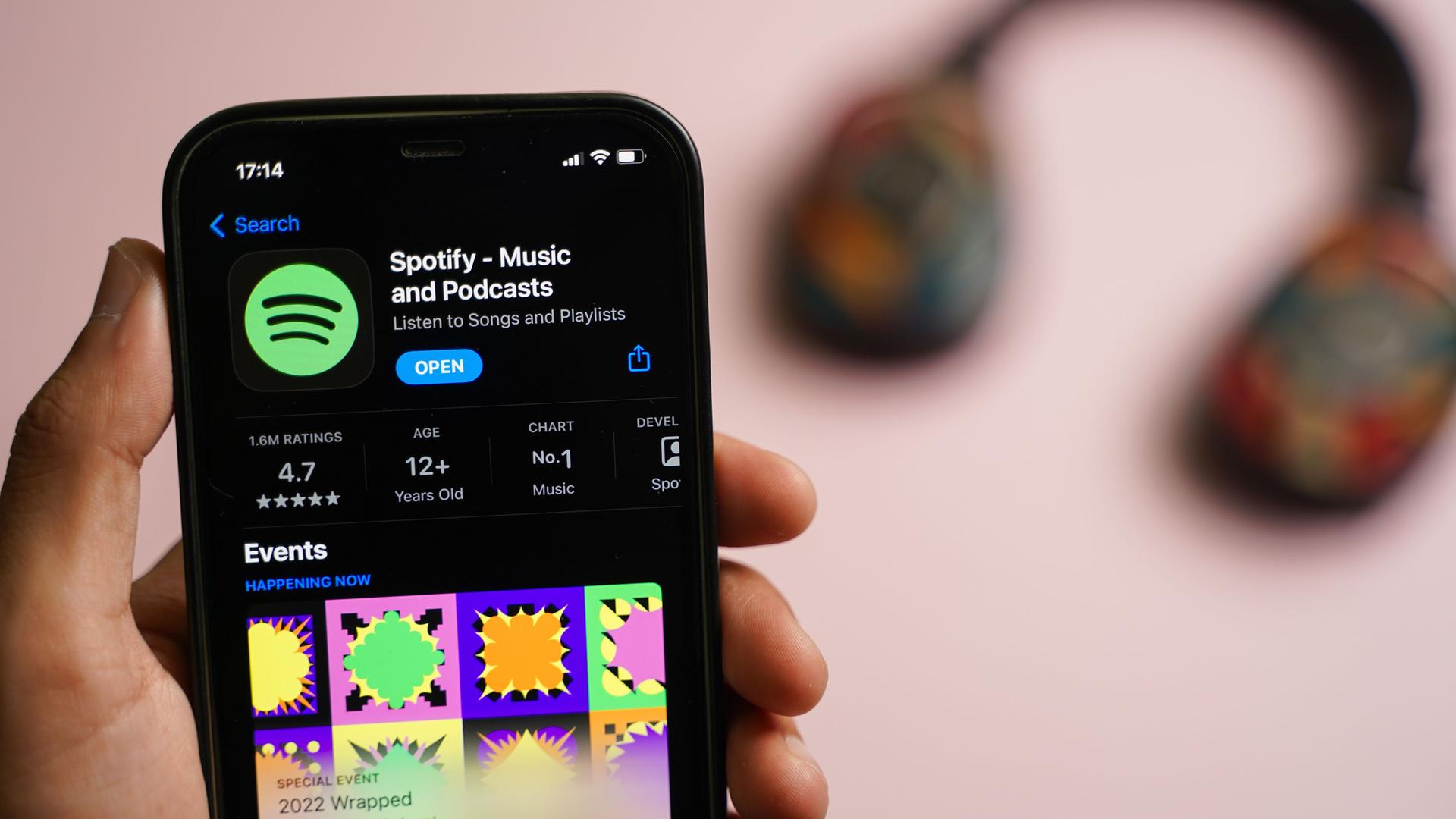 Eine Hand, die ein Smartphone hält, auf ihm ist die Spotify-App geöffnet. Eine Hand, die ein Smartphone hält, auf ihm ist die Spotify-App geöffnet.