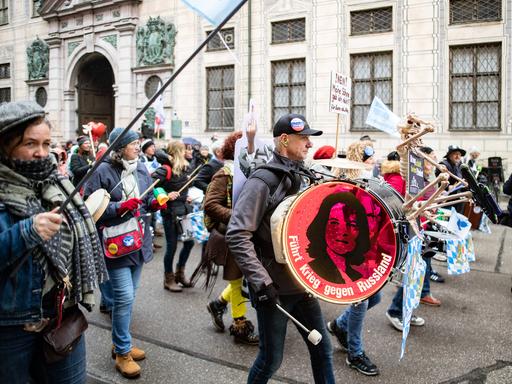 Teilnehmende einer verschwörungsideologischen Demo in München gehen durch die Straßen.