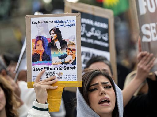 Demonstranten während einer Kundgebung gegen das politische Regime im Iran. Auf einem Schild steht "Say her name #Mahsa Amini". Nach dem Tod der 22-jährigen in Teheran kommt es weltweit zu Protesten und Solidaritätskundgebungen.