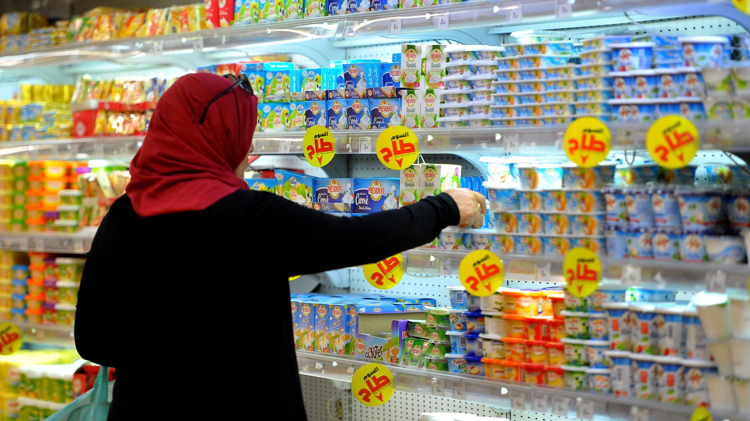 Eine Frau steht in einem tunesischen Supermarkt vor einem Kühlregal mit Milchprodukten