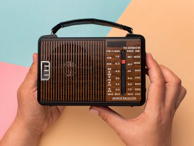 Ein kleines Retro-Radio in der Hand einer Person