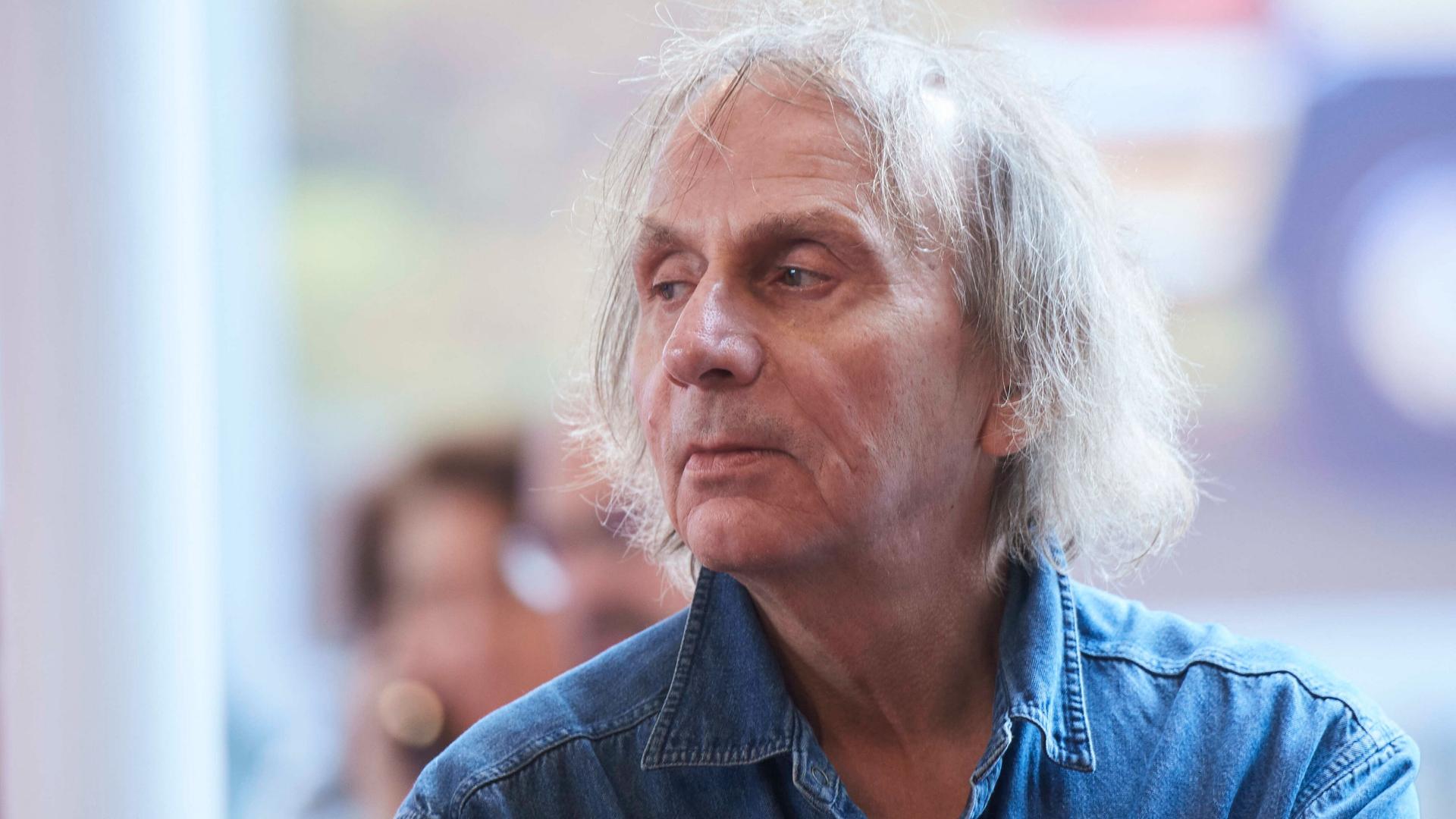 Michel Houellebecq sitzt im Jahr 2020 bei einer Premiere auf einem Stuhl und schaut zur Seite. Michel Houellebecq sitzt im Jahr 2020 bei einer Premiere auf einem Stuhl und schaut zur Seite.