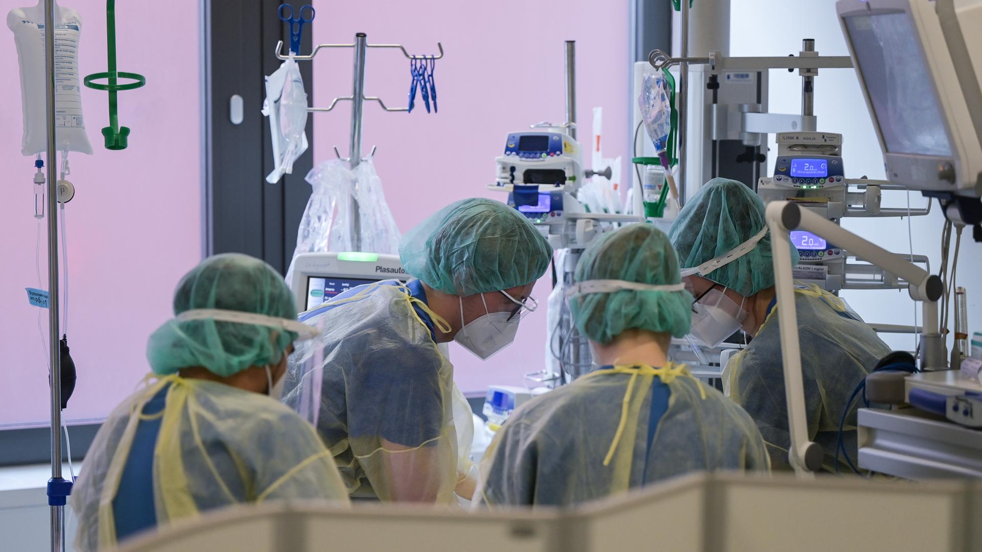 Pfleger und Pflegerinnen sowie eine Ãrztin kümmern sich auf der Intensivstation für Corona-Patienten um einen Patienten. Pfleger und Pflegerinnen sowie eine Ãrztin kümmern sich auf der Intensivstation für Corona-Patienten um einen Patienten.