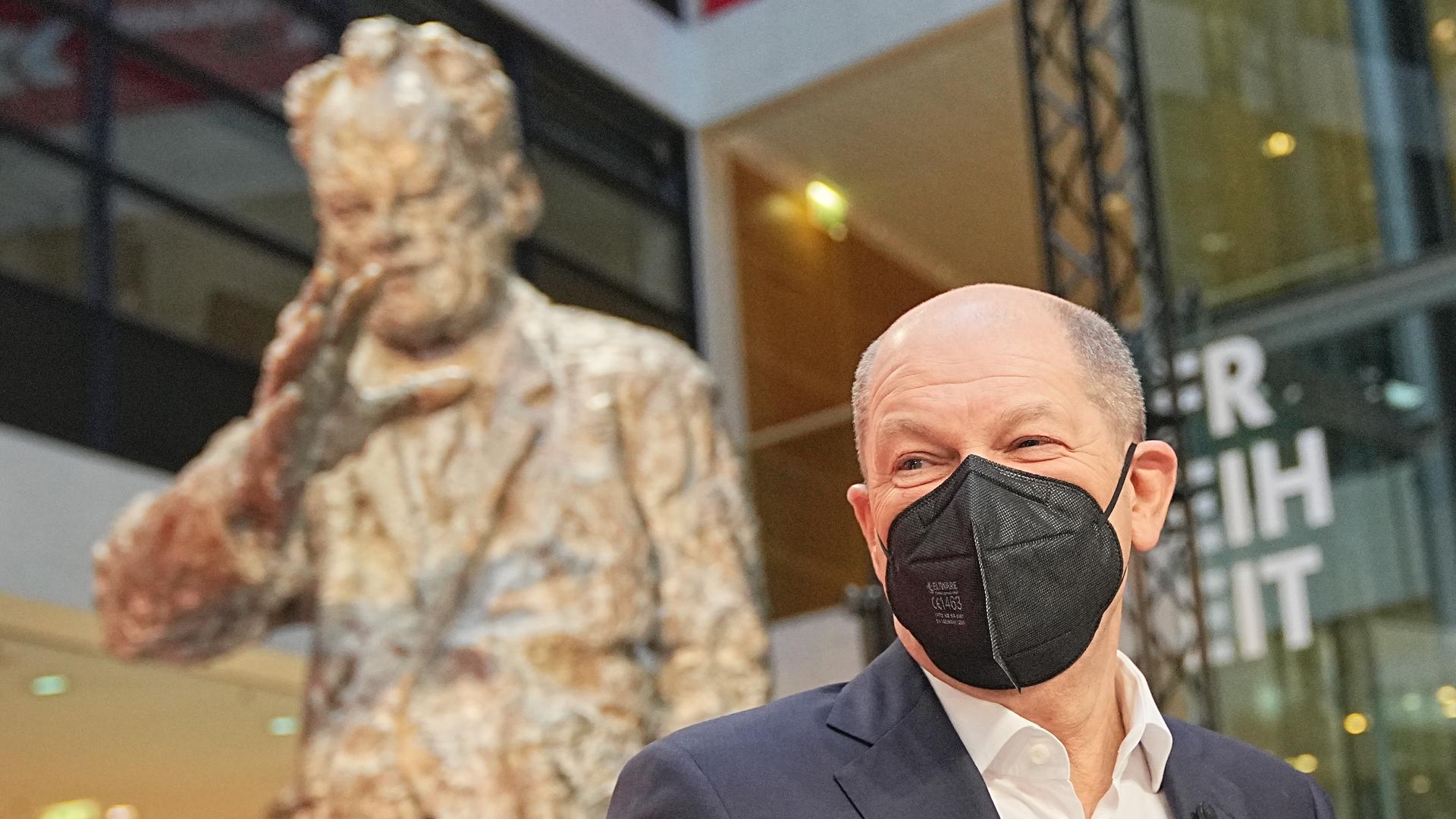 Der zukünftige Bundeskanzler Olaf Scholz neben einer Skulptur des früheren SPD-Bundeskanzlers Willy Brandt. Der zukünftige Bundeskanzler Olaf Scholz neben einer Skulptur des früheren SPD-Bundeskanzlers Willy Brandt.