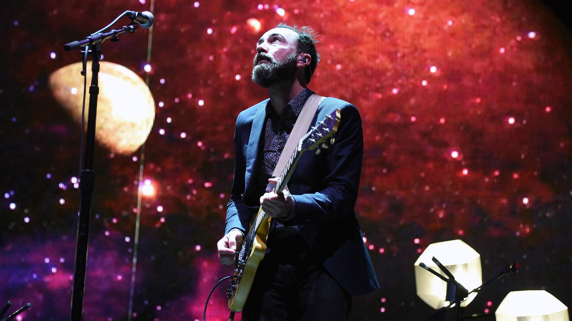 James Mercer von den "Broken Bells" mit Gitarre auf einer Bühne. James Mercer von den "Broken Bells" mit Gitarre auf einer Bühne.