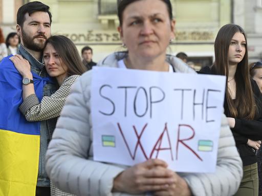 Besucherinnen und Besucher eines Solidaritätskonzerts mit der Ukraine, das Ende März von Warschau/ Polen nach Prag/Tschechien gestreamt wurde - eine Zuhörerin hält ein Schild mit der Aufschrift "Stop War" in der Hand