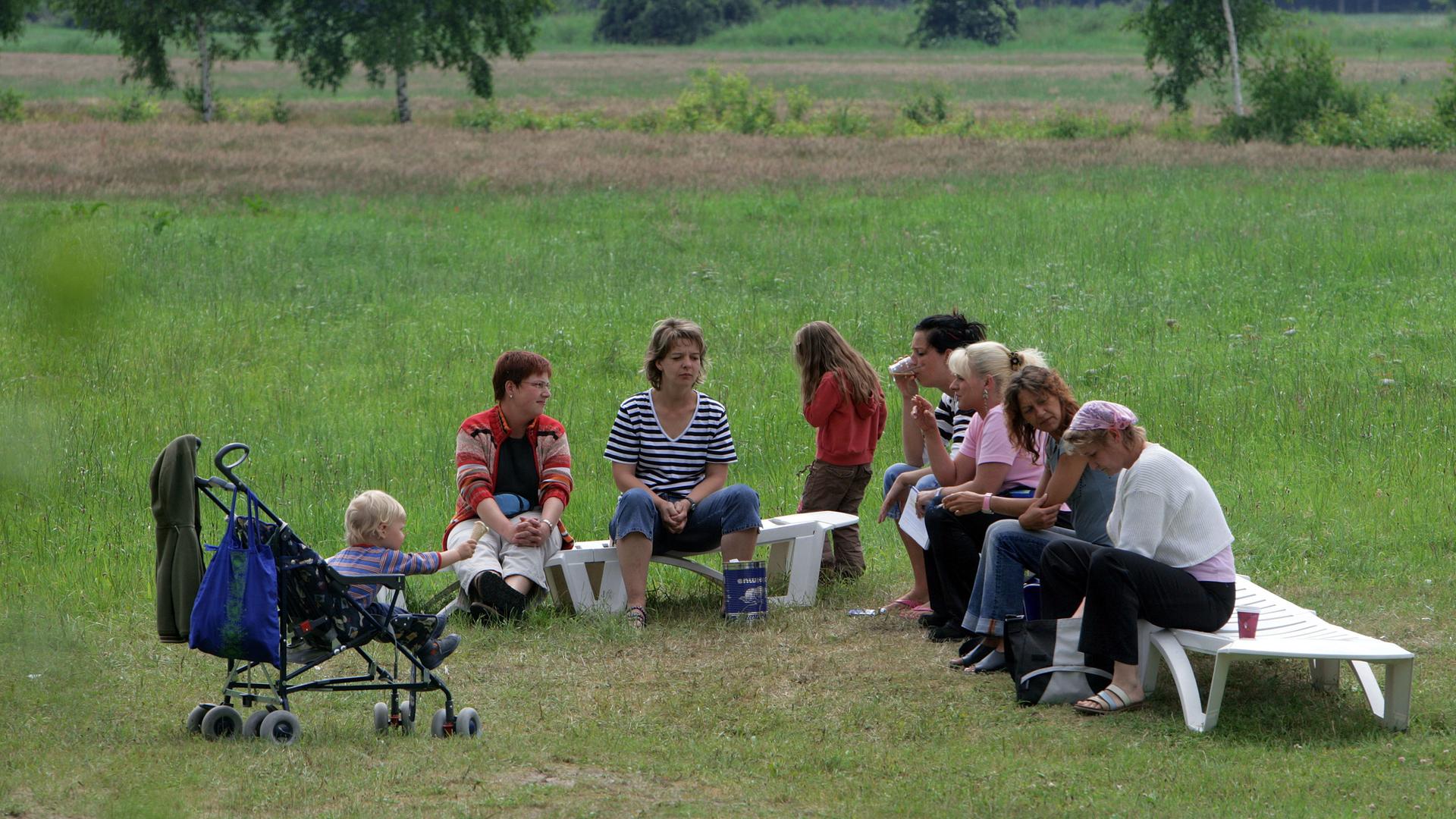 Mütter entspannen sich mit ihren Kindern im Garten einer Klinik, die Mutter-Kind-Kuren anbietet. Mütter entspannen sich mit ihren Kindern im Garten einer Klinik, die Mutter-Kind-Kuren anbietet.