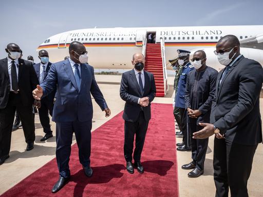Kanzler Scholz wird vom senegalesischen Präsidenten Sall mit militärischen Ehren am Flughafen begrüßt.