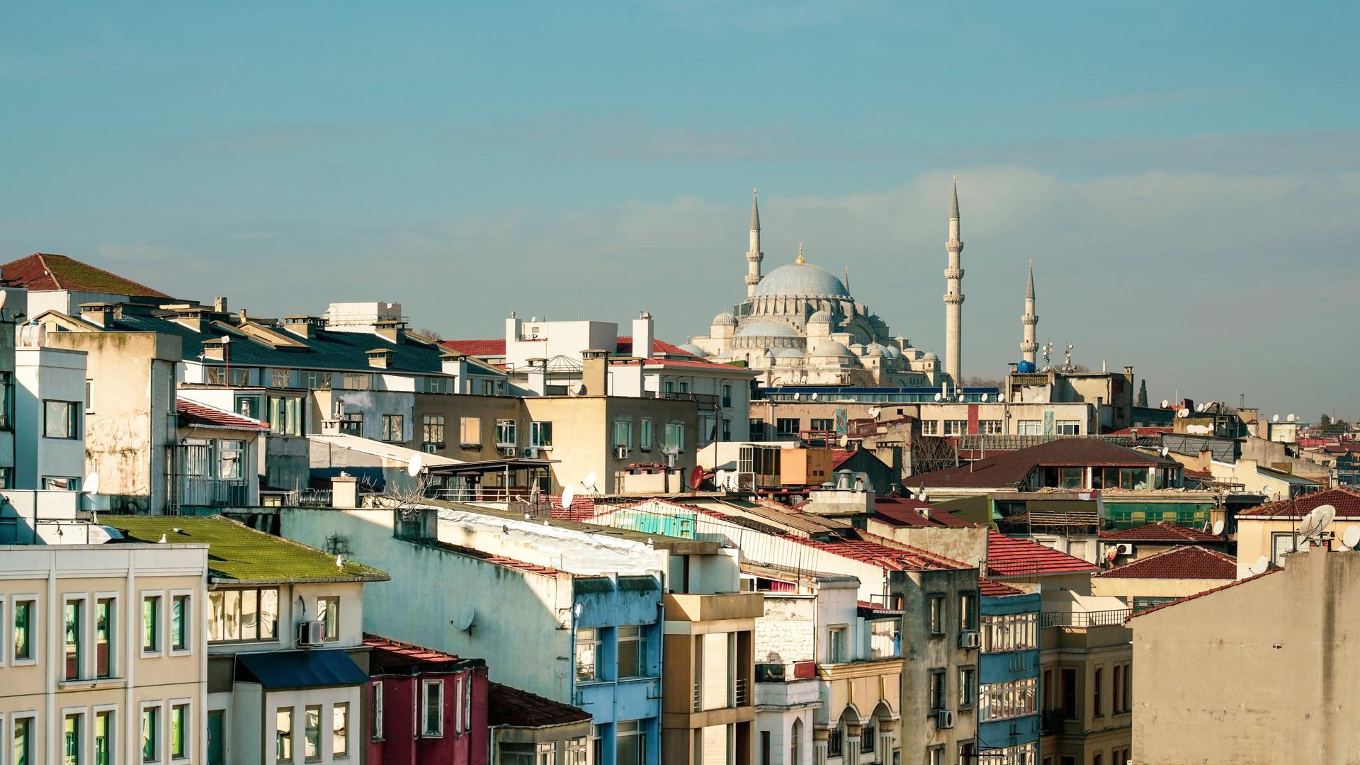 Ein Meer von windschiefen, bunten und eng nebeneinanderstehenden Häusern. Im Hintergrund die Süleymaniye Moschee.