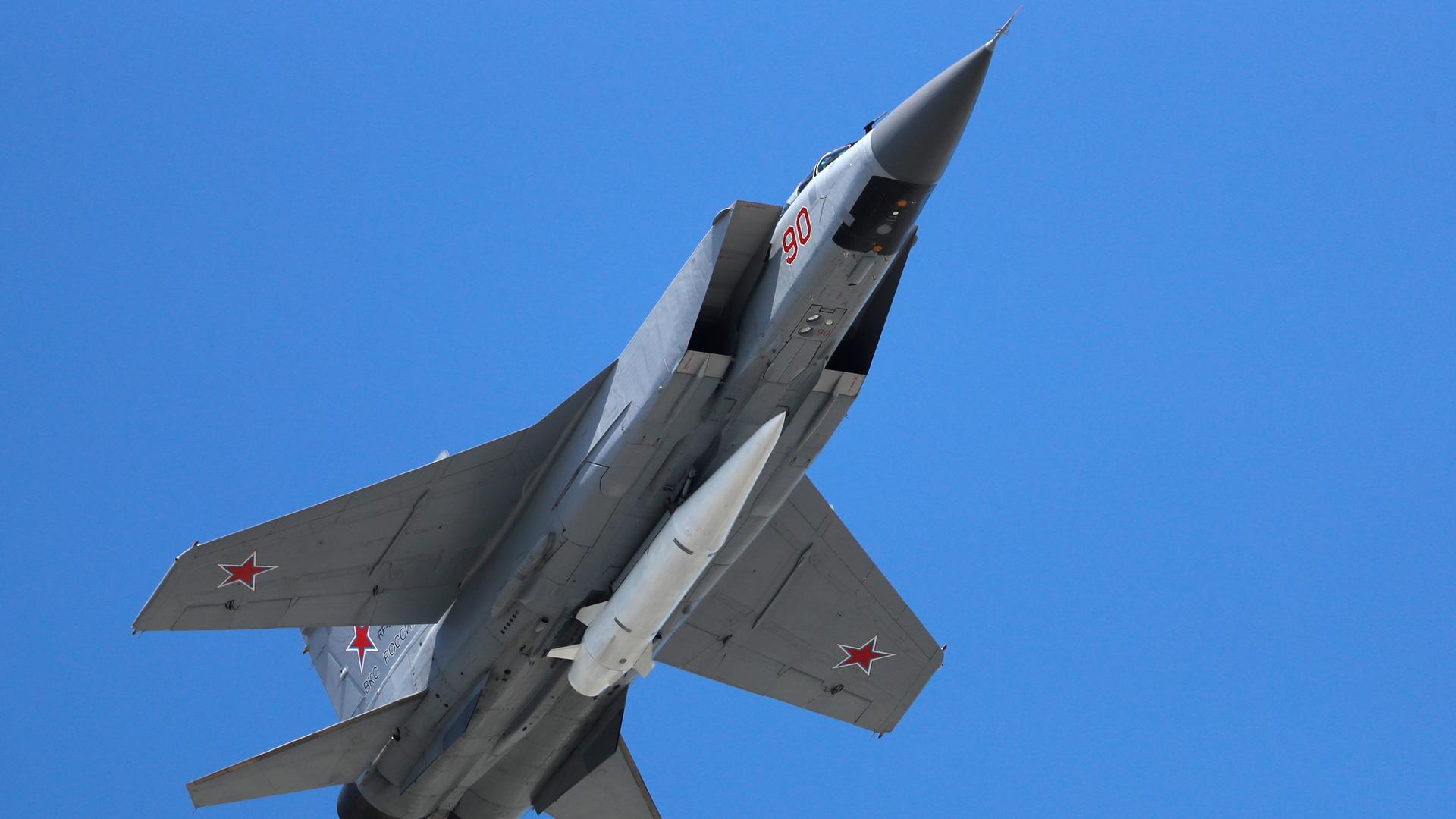 Ein russisches Militärflugzeug in der Luft. Am Rumpf ist eine weiße Rakete befestigt. Ein russisches Militärflugzeug in der Luft. Am Rumpf ist eine weiße Rakete befestigt.