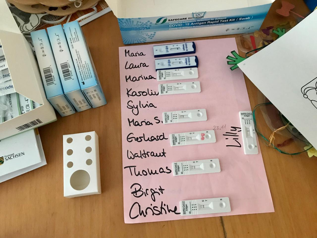 Schnell-Teststreifen von Angestellten der Kita in Lückendorf liegen auf einem Bogen Papier mit den jeweiligen Namen.