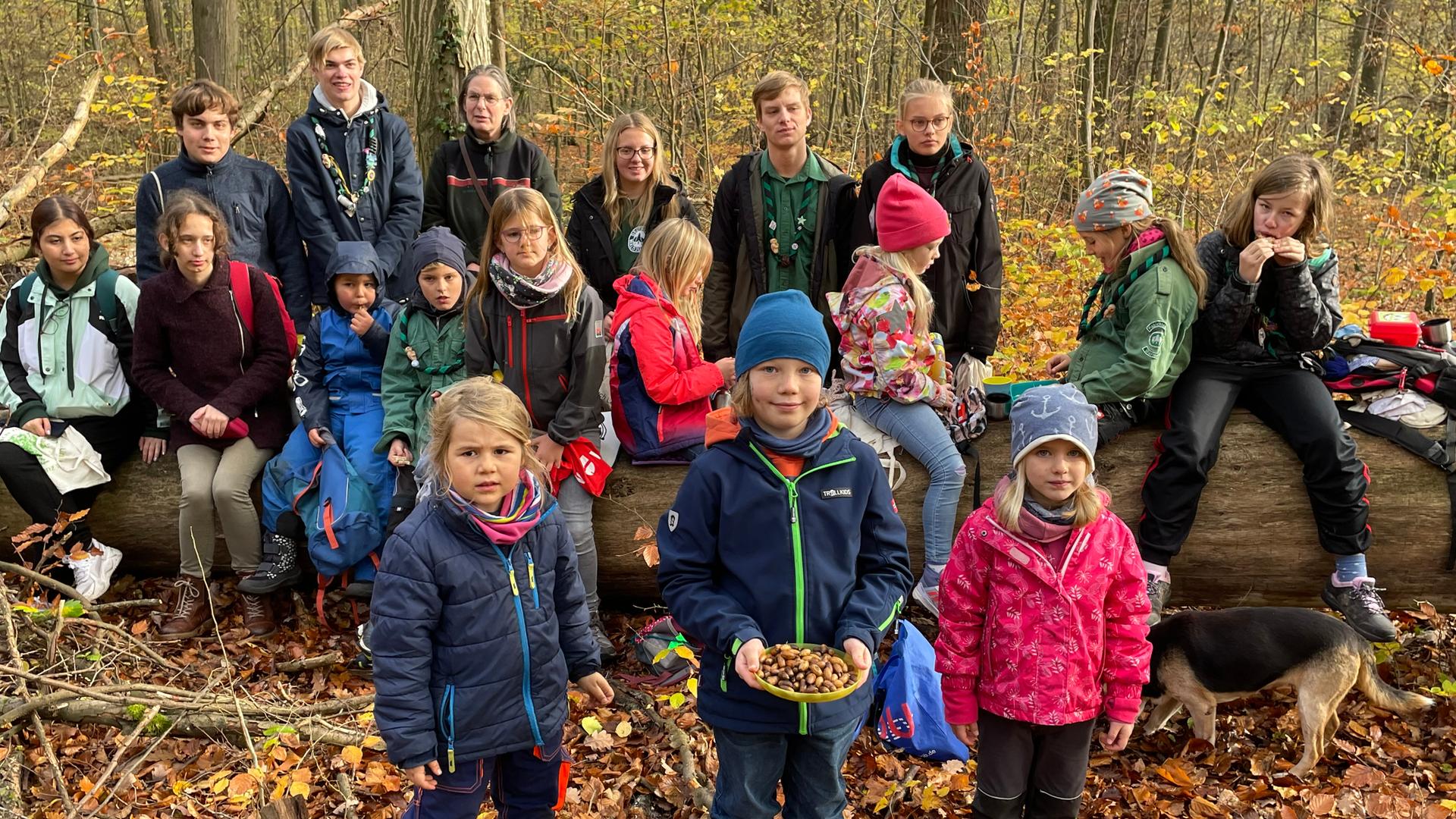 Eine Gruppe Kinder, die sich in der Waldjugend engagiert, steht im Wald. Eine Gruppe Kinder, die sich in der Waldjugend engagiert, steht im Wald.