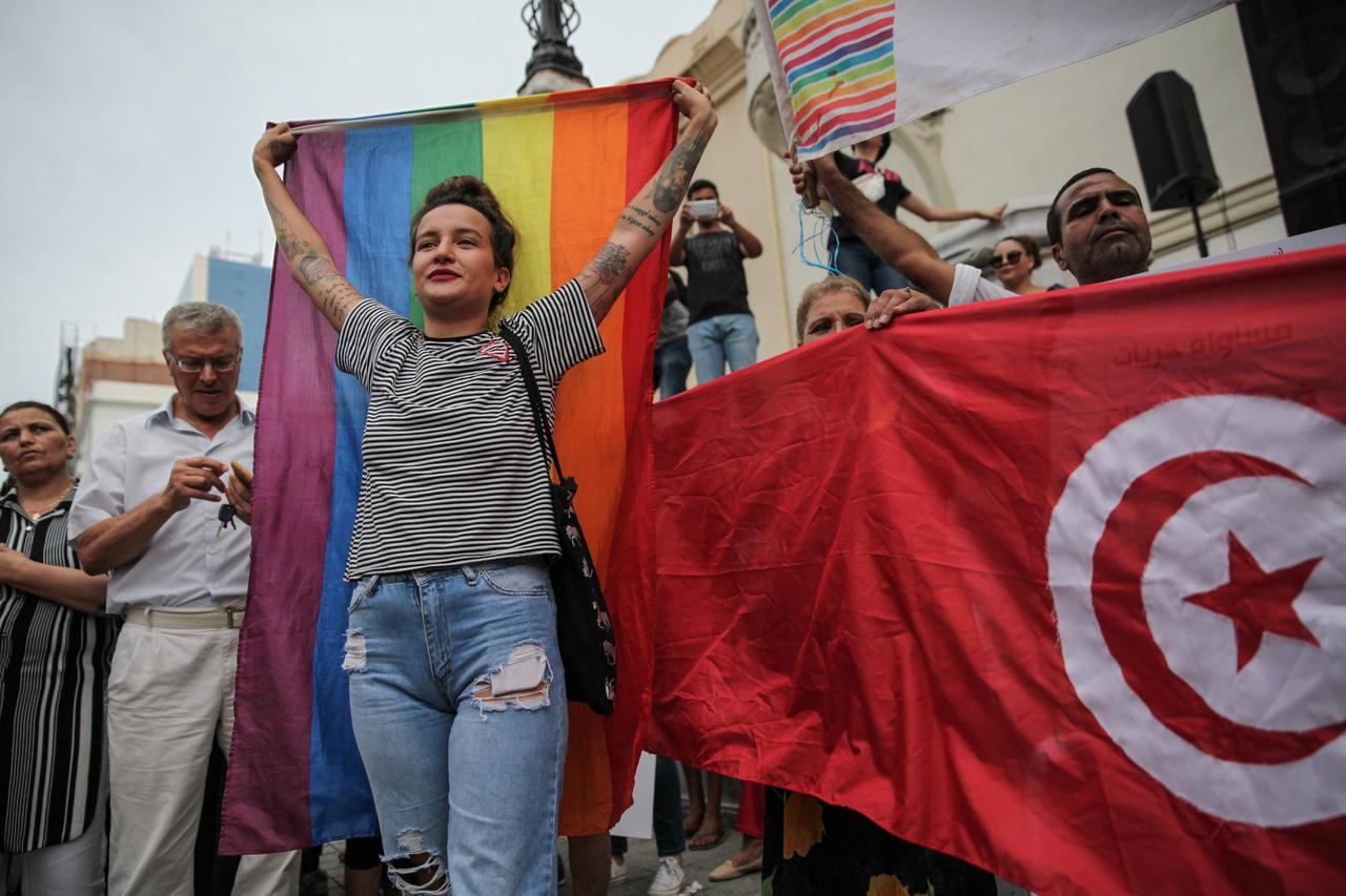 Amina Sboui, ehemalige Femen, hält bei einer Demonstration am Nationalen Frauentag im August 2018 in Tunis eine Regenbogenflagge hoch. Daneben sind weitere Demonstranten mit der tunesischen Flagge zu sehen. Amina Sboui, ehemalige Femen, hält bei einer Demonstration am Nationalen Frauentag im August 2018 in Tunis eine Regenbogenflagge hoch. Daneben sind weitere Demonstranten mit der tunesischen Flagge zu sehen.