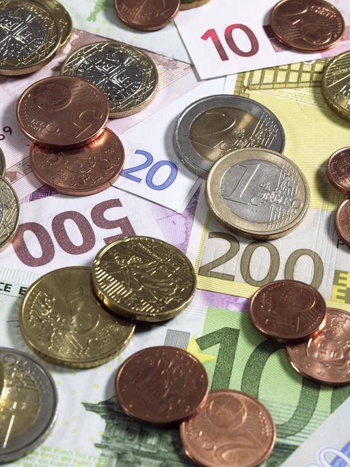 Euro-Münzen auf 10-, 20-, 100-, 200- und 500-Euro-Banknoten.