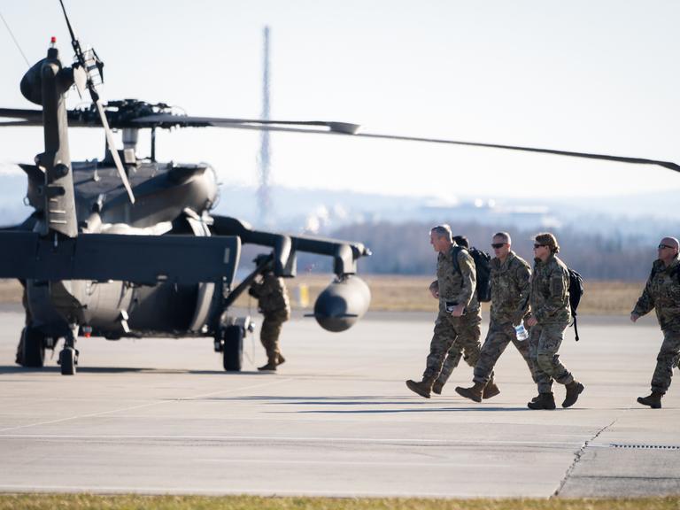 Der Transporthubschrauber Sikorsky UH-60 Black Hawk landet auf dem Flughafen Rzeszow-Jasionka in Polen. US-Soldaten laufen über das Rollfeld, aufgenommen am 13. Februar 2022