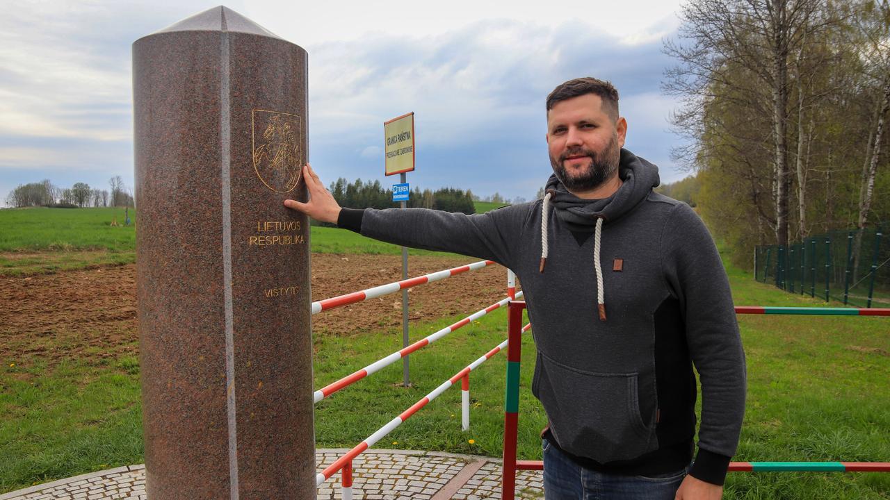 Ein Mann lehnt sich an einen Grenzstein Ein Mann lehnt sich an einen Grenzstein